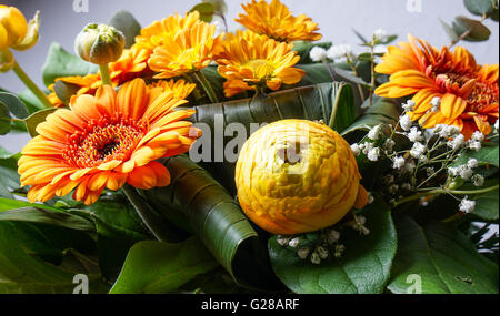 bouquet of orange flowers, perfect for Mothers day or birthdays. Peonies, Bridal Veils, green leaves and daisies Stock Photo