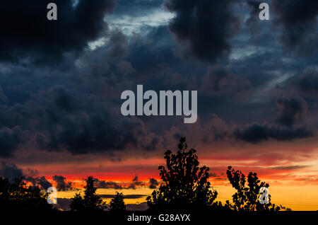 Sunset in dark cloudy sky background Stock Photo