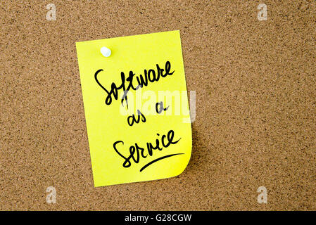 Software As A Service written on yellow paper note pinned on cork board with white thumbtack, copy space available Stock Photo