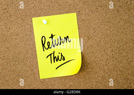 Return This written on yellow paper note pinned on cork board with white thumbtack, copy space available Stock Photo
