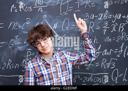 Boy and blackboard filled with math formulas Stock Photo