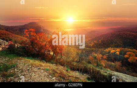 Bright sun over mountains in red autumn Stock Photo