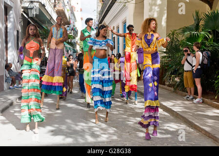 A group of stilt dancers entertaining locals and tourists in the Old Town of Havana collecting whatever money is given too them. Stock Photo
