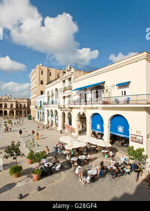 A vertical view of Plaza Vieja in the Old Town of Havana with a restaurant cafe in the foreground. Stock Photo