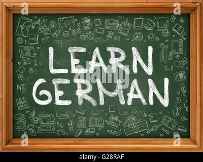 Learn German Concept. Green Chalkboard with Doodle Icons. Stock Photo