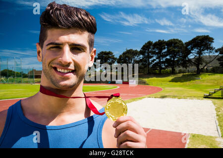 Composite image of portrait of happy sportsman is showing his medal Stock Photo