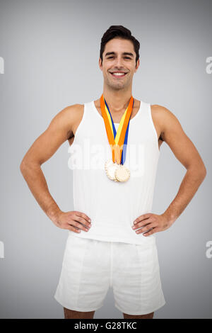 Composite image of athlete posing with gold medals around his neck Stock Photo