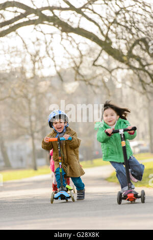 Kids playing with kickboards in a park Stock Photo