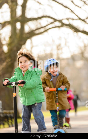 Kids playing with kickboards in a park Stock Photo