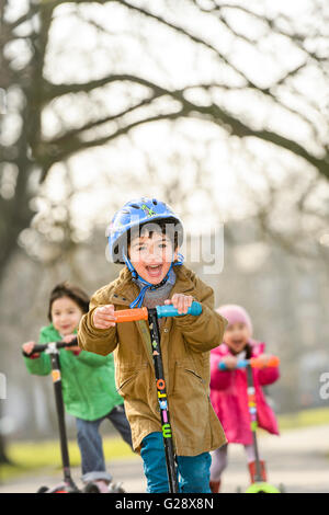 Kids playing with kickboards in a park Stock Photo