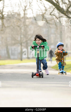 Kids playing with kickboards in a park Stock Photo