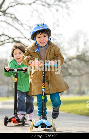 Kids playing with kickboards in a park Stock Photo