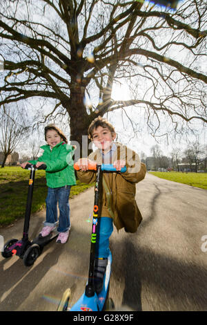Kids playing with kickboards in a park Stock Photo