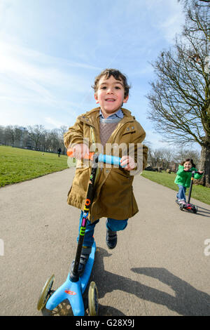 Kids playing with kickboards in a park Stock Photo