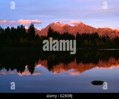 USA, Colorado, Gunnison National Forest. Alpenglow on Mount Owens in the Ruby Range which reflects in Lost Lake Slough. Stock Photo