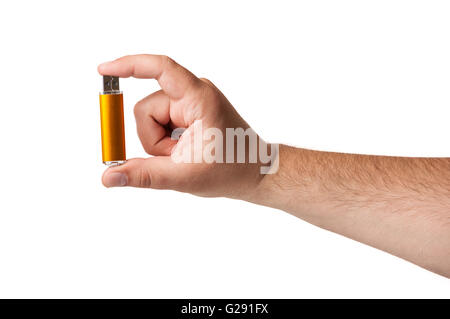 A small golden USB flash drive held between fingers isolated on a white background Stock Photo