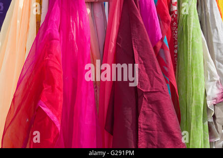 Close up on colourful cotton scarves hanging on a rail, for sale at Tewkesbury Medieval Festival, UK Stock Photo