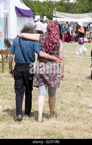 Tewkesbury, UK-July 17, 2015: Mature hippy couple walk arm in arm on 17 July 2015 at Tewkesbury Medieval Festival Stock Photo