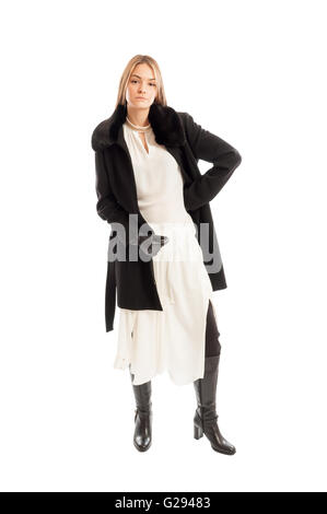 Female model wearing black wool coat on white dress and leather boots isolated on white background Stock Photo