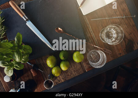 Making a cold fresh basil smash cocktail. Empty glass and ingredients on counter in bar. Stock Photo