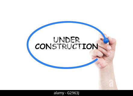 Under construction text write on transparent wipe board by hand holding a marker Stock Photo
