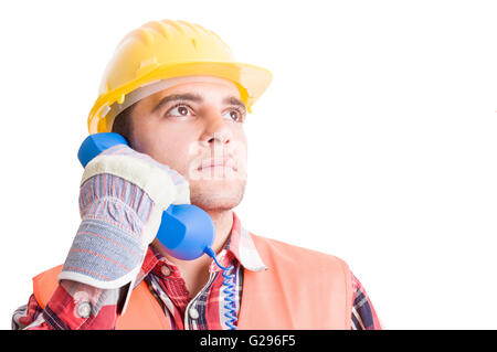 Visionary and confident builder talking on the phone and looking up Stock Photo