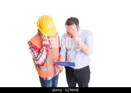 Stressed engineer and upset builder checking clipboard. Construction concept on white background Stock Photo