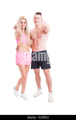 Active couple of fitness trainers or instructors showing like and smiling isolated on white Stock Photo