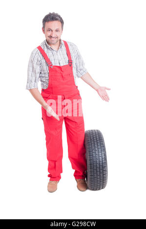 Mechanic showing new car tire isolated on white background Stock Photo