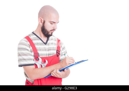 Young mechanic writing on clipboard isolated on white Stock Photo