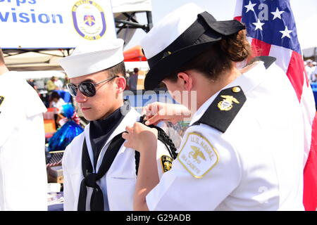 New York City, United States. 25th May, 2016. LT Michael Murphy Division US Naval Sea Cadet Corps member gets help with ceremonial aiguillette. The 28th annual NYC Fleet Week brought US navy & coast guard ships to the Brooklyn Ferry Terminal in Red Hook where sailors, guard & marines were greeted with entertainment, awards & hearty bbq plates. Credit:  Andy Katz/Pacific Press/Alamy Live News Stock Photo