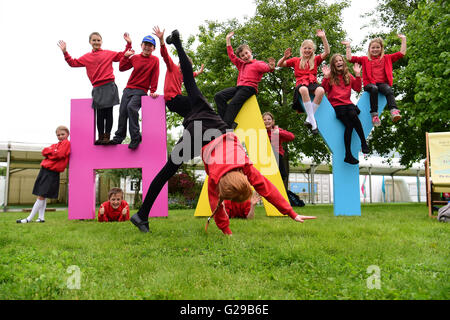 Hay on Wye, Wales, UK. 26th May, 2016.  The opening day of the Hay Festival 2016, and pupils from Burghill Communit Academy in Herefordshire  have fun with the huge Hay sign on the festival site   photo Credit:  keith morris/Alamy Live News Stock Photo