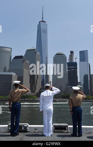 US Sailors and Marines aboard the amphibious assault ship USS Bataan man the rails to salute One World Trade Center in Manhattan as they pull into port for Fleet Week May 25, 2016 in New York City, NY. Stock Photo