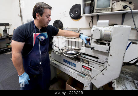 Camarillo, California, USA. 25th May, 2016. JORGE ROCHA trims the stamper at the record pressing plant, Record Technology, Inc. Founded in 1978, Music Matters Jazz is dedicated to re-releasing new pressings of historic Blue Note Records jazz titles on 45 and 33 RPM, 180g virgin vinyl. Each of the re-issued jazz albums is restored and remastered from the original master analog tapes and features the iconic Blue Note cover art with gatefold jackets and additional photos from the original sessions. © Brian Cahn/ZUMA Wire/Alamy Live News Stock Photo
