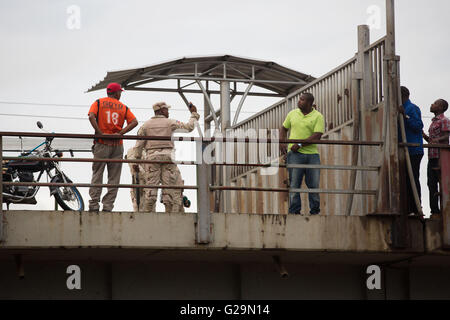 May 27, 2016 - After he illegally climbed over from Haiti, Military Police shout at & send back this Haitian man over the unopened gate on the bridge at the Dominican Republic border in Dajabon May 27, 2016. Many Haitians illegally cross the border every Monday and Friday before it opens at 8am to sell their goods at the market. © Louise Wateridge/ZUMA Wire/Alamy Live News Stock Photo