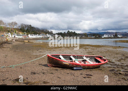 A weathered red boat on the beach in the village of Plockton, Ross Shire in Scotland UK Stock Photo