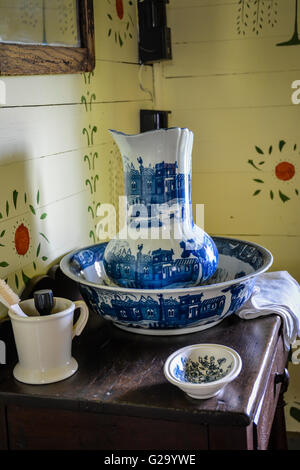 An Interior view of a rustic 19th Century American wash stand with pitcher and hand decorated walls Stock Photo