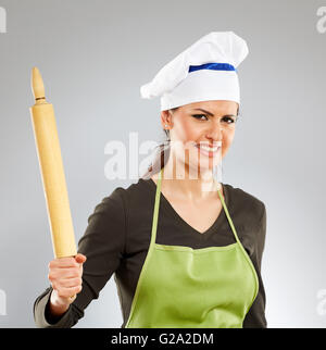 Angry female cook with a rolling pin over gray background Stock Photo