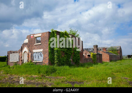 Deserted, unsafe, overgrown 1803 Red brick Farm House, building, in poor repair a dangerous structure in Burscough, Lancashire, UK Stock Photo