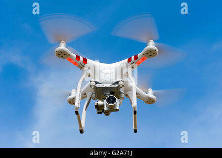 Quadrocopter, drone, with camera flying against a blue sky, DJI Phantom 3 Stock Photo