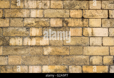 Background of old yellow aged brick wall. Stock Photo
