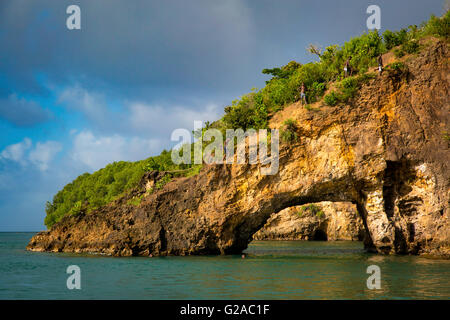 Local island kids scrambling up the rocks to jump into the sea, St Lucia, West Indies Stock Photo