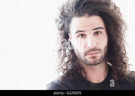 Portrait of young man with long curly hair Stock Photo