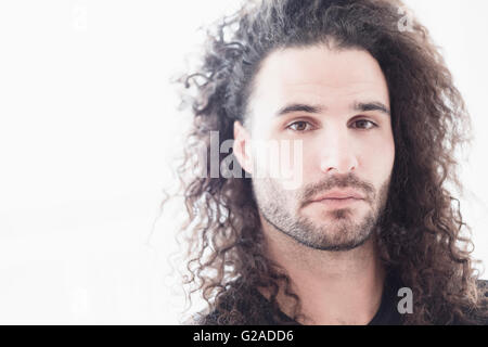 Portrait of young man with long curly hair Stock Photo