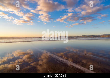 cloudy sky reflected on sea shore Stock Photo - Alamy