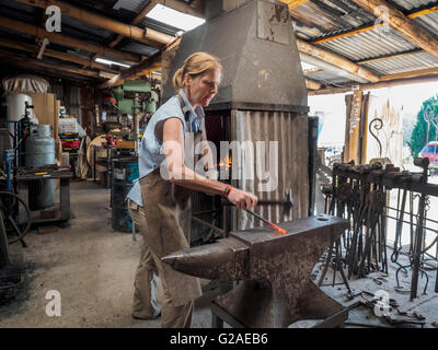 Female blacksmith working in workshop Stock Photo