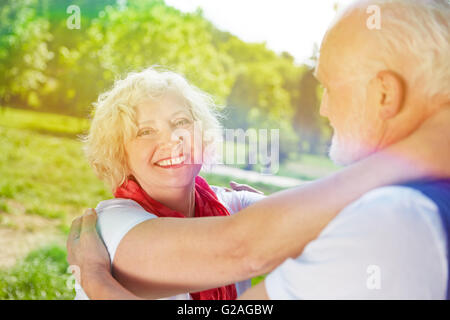 Happy senior caouple dancing together in summer in a park Stock Photo