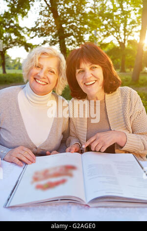 Two elderly women browsing old photographs at a village history open ...