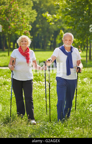 Happy senior couple doing Nordic Walking in summer in nature Stock Photo