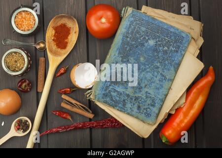 Recipe book and vegetables. Chili pepper and tomatoes. Food preparation according to the old recipe book. Grandma's recipe book. Stock Photo